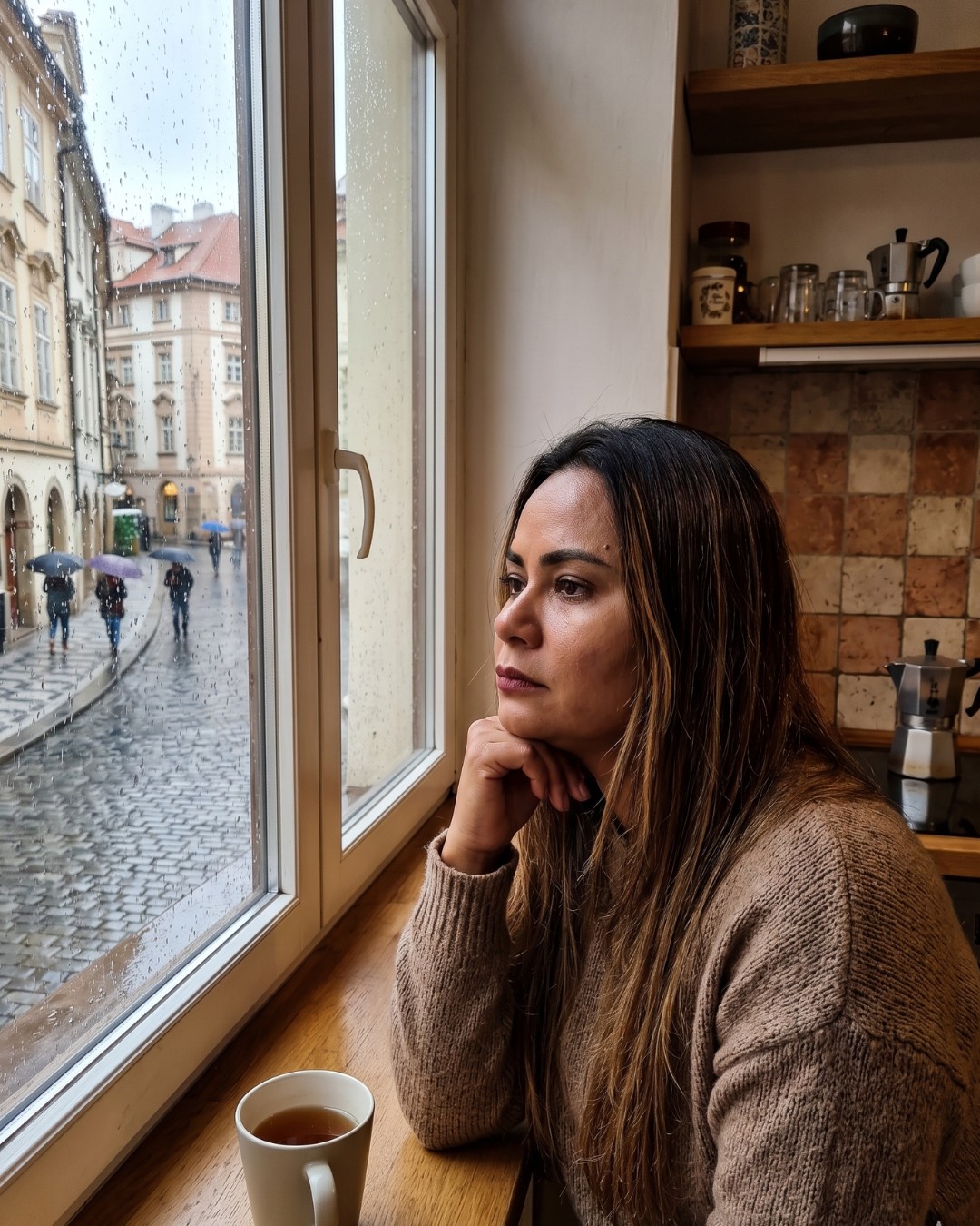 Brasileira na Europa olhando pela janela